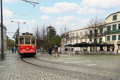 Montpellier with a modern Tramway. The Montpellier tramway has four lines with 84 stations.  The image shows a tram stopping at a station, captured during autumn season.