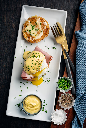 Eggs Benedict with ham and hollandaise sauce. Colour, vertical format with some copy space. Please see my others pictures in this series for more.
