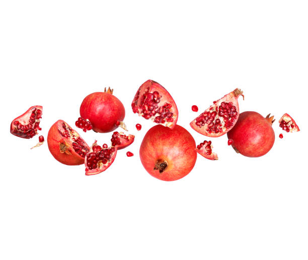 istock Whole and sliced pomegranate in the air on a white background 1389484929
