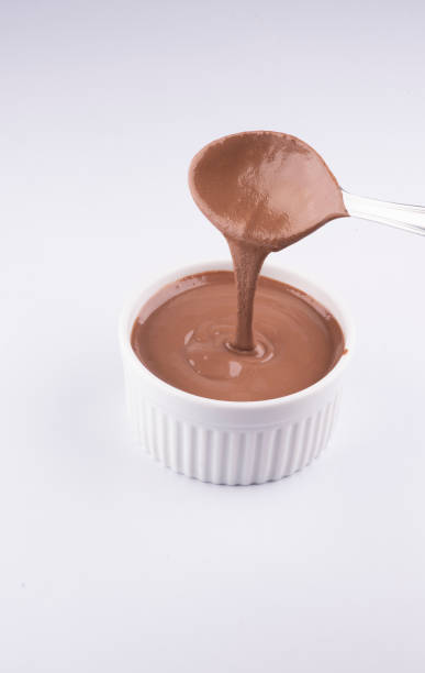istock pouring om spoon creamy peanut butter into jar isolated on white background 1389485166