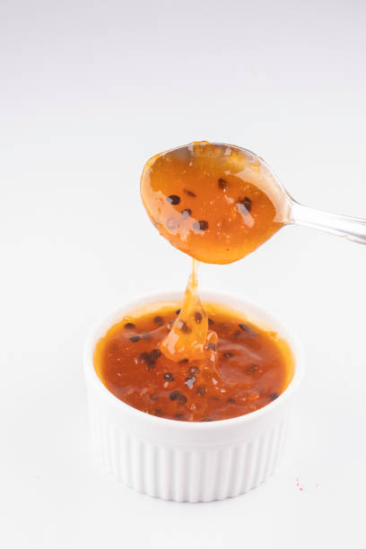 istock pouring passion fruit jam with spoon into white pot isolated on white background 1389485191