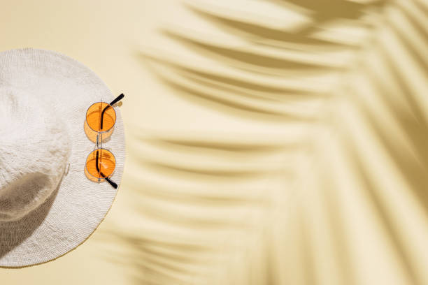 istock Summer beach rest concept background with sunhat, colored sunglasses on sandy color paper. Flat lay with woman accessory 1389485303