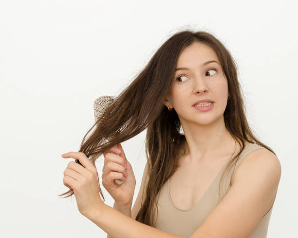 istock a woman is brushing her hair with a comb 1389485881