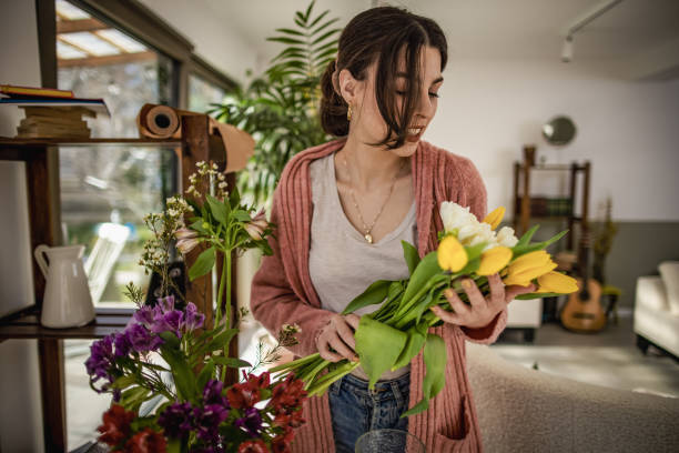istock Woman with spring flowers at home 1389486134