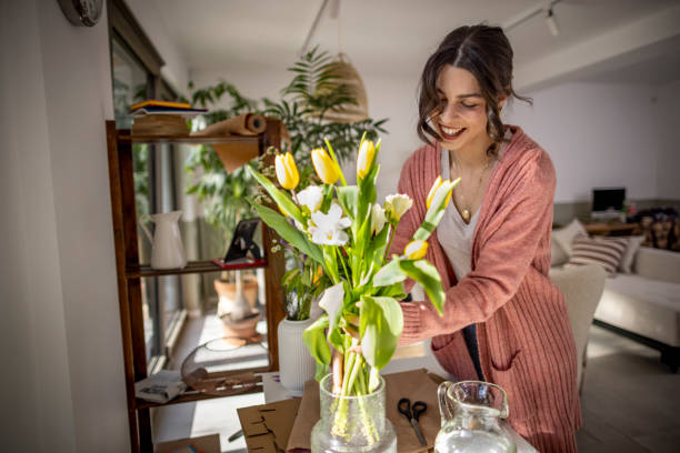 istock Smiling woman arranging flowers at home 1389486549
