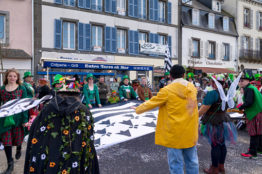 Landerneau, France - April 03 2022: Huge flag of Brittany (Gwenn ha du) spread by members of a celtic themed float of the Carnaval de la Lune Etoilée.