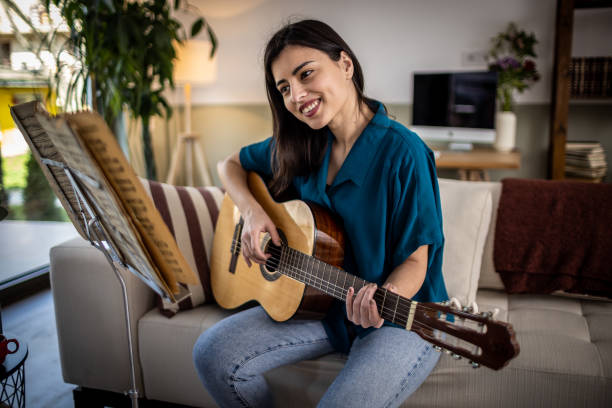 istock Playing a guitar at home 1389489379