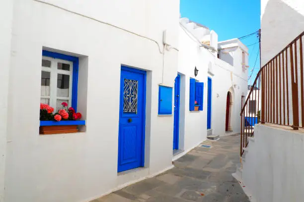 Photo of One of the charms of the Cyclades (here, in Pyrgos on the island of Tinos), in the heart of the Aegean Sea, are the narrow streets: white houses, colorful doors, flowery balconies and cobbled streets