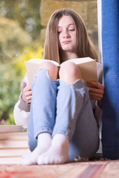 istock Young girl reading on the floor 1389490977