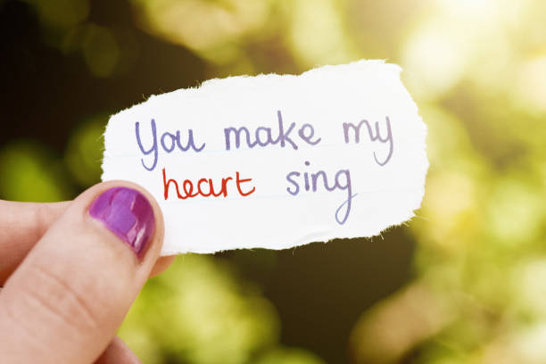 istock You make my heart sing, says note held by young female hand 1389491945