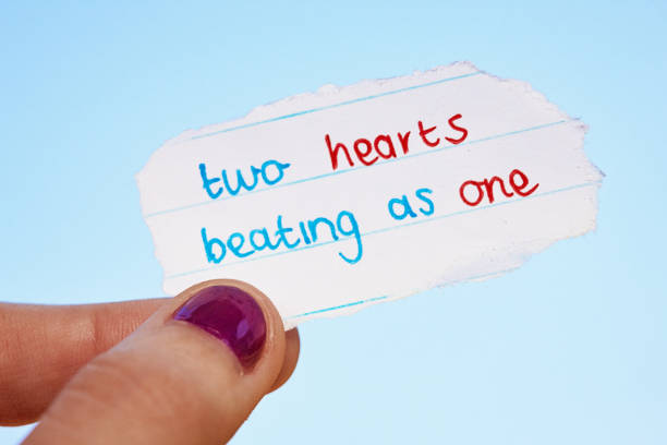 istock Two hearts beating as one, says note held by young female hand 1389491988