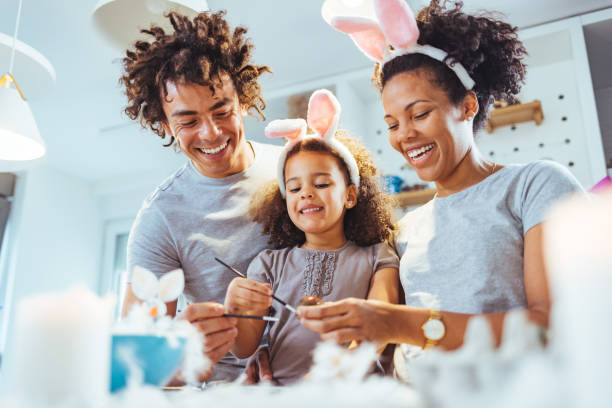 Close up of a loving couple preparing for an Easter Shot of a family painting Easter eggs together at home during the day. easter stock pictures, royalty-free photos & images