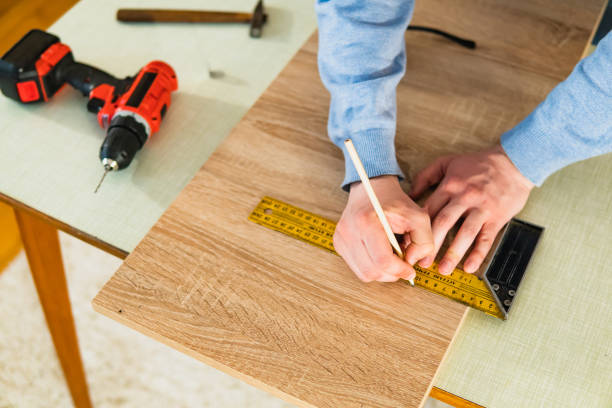 미터를 사용하여 집에서 만드는 가구에 나무 판(합판)을 표시하는 젊은이의 손을 가까이. 집에서 diy 프로젝트. - drill repairing installing home improvement 뉴스 사진 이미지