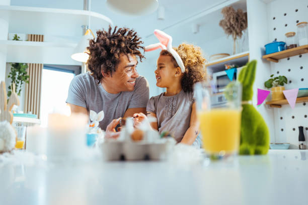 Lets get creative A photo of father and daughter colouring Easter egg together. easter egg coloring stock pictures, royalty-free photos & images