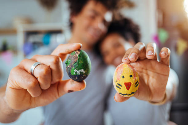 Young couple coloring eggs together. Couple prepairing eggs for easter celebration