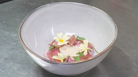 Tuna tartare topped with edible flowers and fresh herbs to garnish