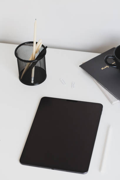 istock Digital tablet on office desk table with stationery top view. Modern, minimal style workspace. 1389496292