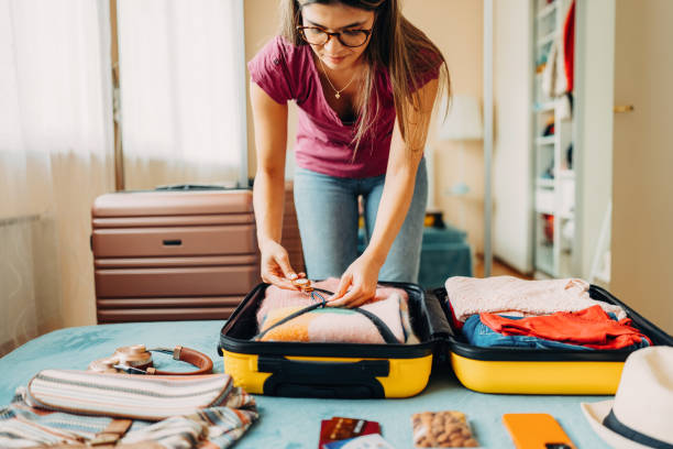 femme emballant une valise pour voyager - empaqueter photos et images de collection