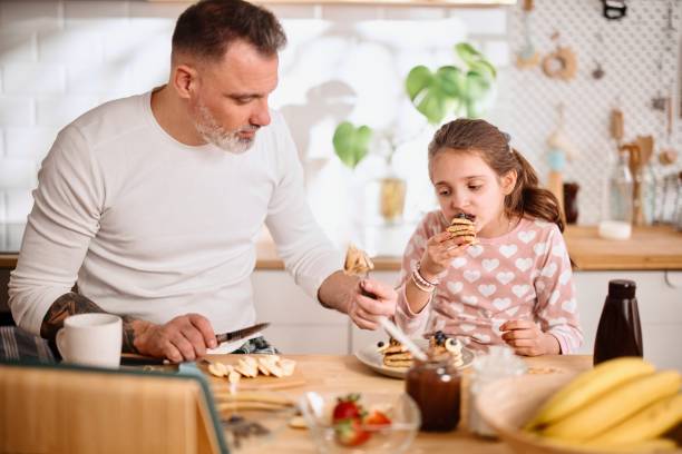 istock Father and daughter eating breakfast together on a weekend 1389497338