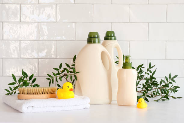 istock Eco organic laundry detergent bottles packaging design. Clean detergent bottles, towels, brush, duck toys, green leaves on table. 1389497353