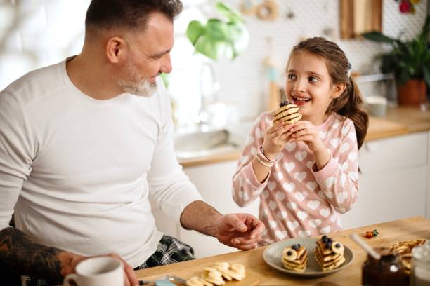 istock Father and daughter eating breakfast together on a weekend 1389497364