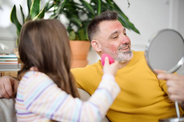 Dad and Daughter Playtime Putting on Makeup Little girl putting makeup on her father. Masculinity undone concept happy fathers day funny stock pictures, royalty-free photos & images