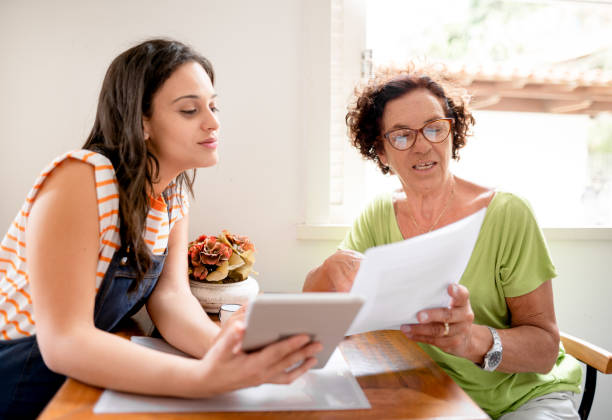 istock Woman helping her mom with home finances using a digital tablet 1389497729