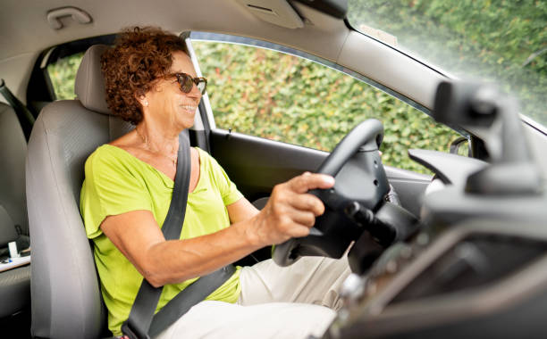istock Mature woman smiling while driving alone in her car 1389497764