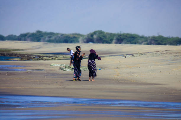 At low tide, locals walk along the shore and shallow water and collect shells from hermit crabs and snails. It is north of Toliara on South West coast of Madagascar.