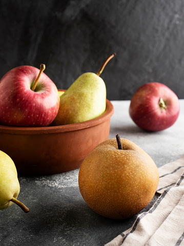 pears in a dark tree table. pears in a basket are also scattered.pears in a basket are accurately put. duchess pear the fragrant beautiful