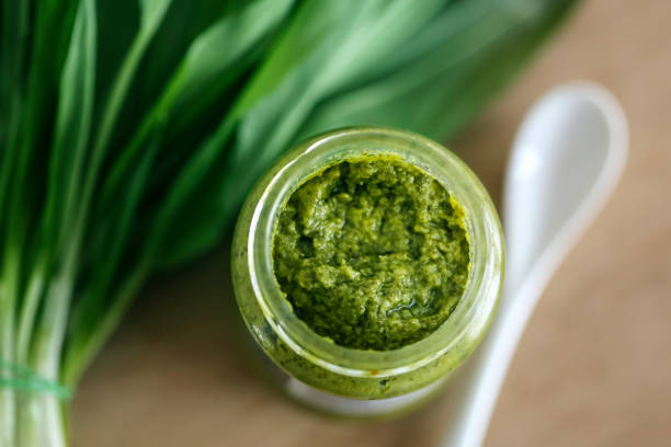 Homemade pesto made from fresh ramsons or wild garlic on wooden background.