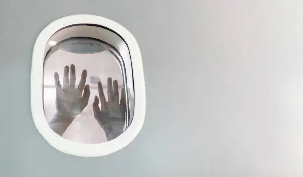 Photo of Passenger hand suffocating and asking for help while stuck inside the airplane after catastrophic accident for plane crash and hijack concept with copy space