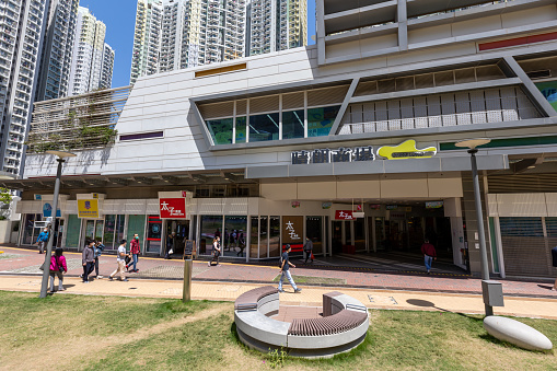 Hong Kong - April 4, 2022 : People walk past the Ching Long Shopping Centre in Kai Tak Development Area, Hong Kong. It provides shopping facilities of daily necessities for residents of Kai Ching Estate, Tak Long Estate and neighboring areas.