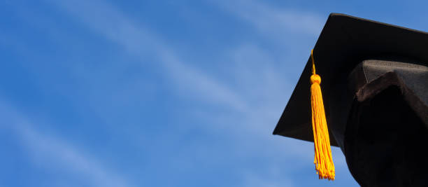 istock Graduation Caps Thrown in the Air blue sky on background 1389508623