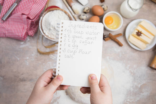 istock blank notebook for recipes in child hands. 1389509504