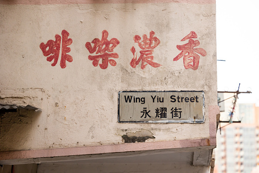 Hong Kong - April 4, 2022 : Wing Yiu Street sign and a coffee shop sign in To Kwa Wan, Kowloon, Hong Kong