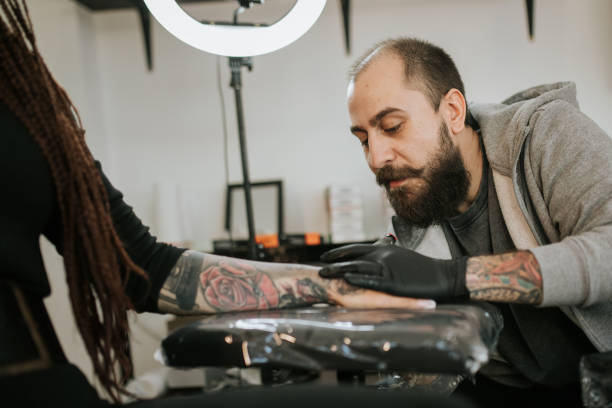 istock Young woman is getting tattoo on her hand 1389512448