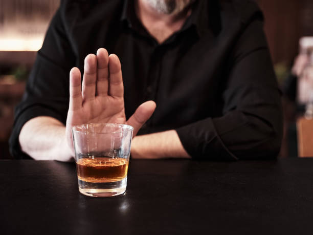 Man refuses or rejects to drink alcohol at the pub. Man refuses or rejects to drink alcohol at the pub. Alcohol addiction treatment, sobriety and drinking problem. alcohol stock pictures, royalty-free photos & images