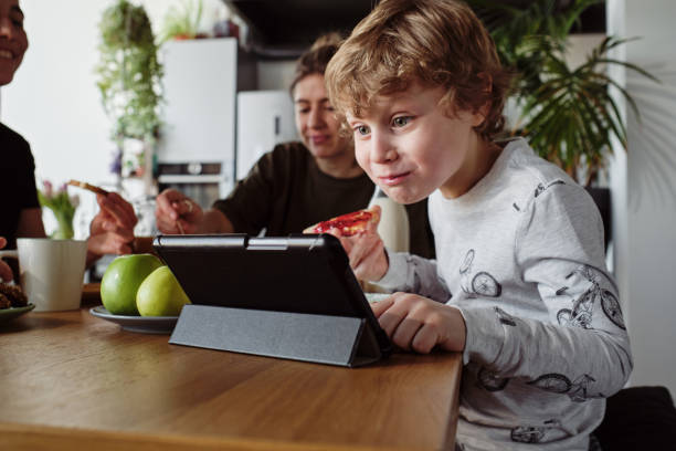 boy watching video during breakfast - family mother domestic life food imagens e fotografias de stock