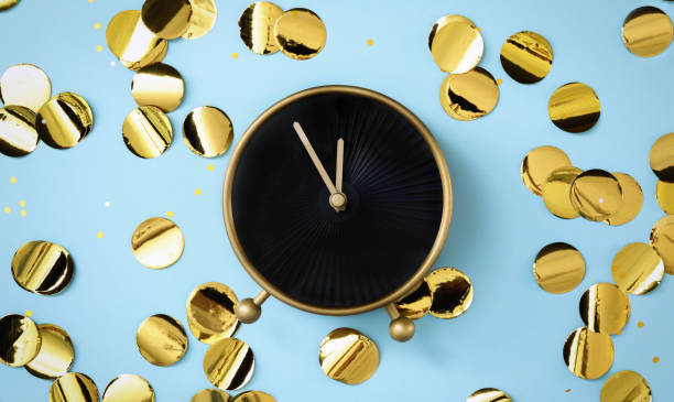 istock Alarm clock and golden confetti on light blue background, flat lay. New Year countdown 1389515076