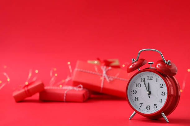 istock Alarm clock and gifts on red background, space for text. New Year countdown 1389516324
