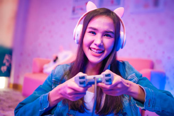 istock Young asian woman is using virtual reality headset. Neon light studio portrait. Concept of virtual reality, simulation, gaming and future technology.Asian woman play game in living room. 1389516339