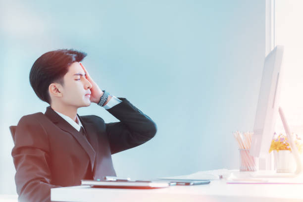 Young Businessman is exhausted and frustated after a long hour of work in office. stock photo