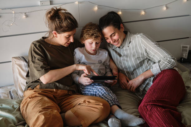 rodzina korzystająca z tabletu cyfrowego razem - homosexual lesbian family parent zdjęcia i obrazy z banku zdjęć