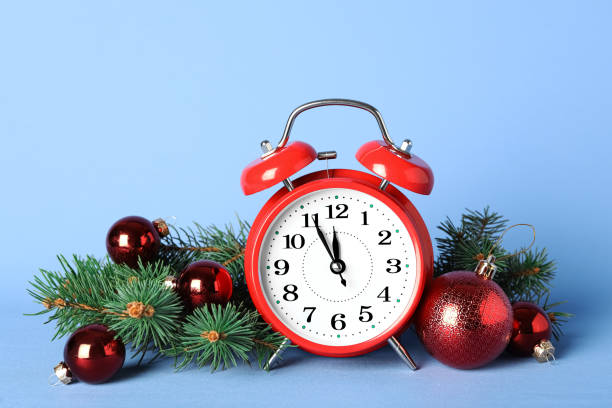 istock Alarm clock with Christmas decor on light blue background. New Year countdown 1389516809