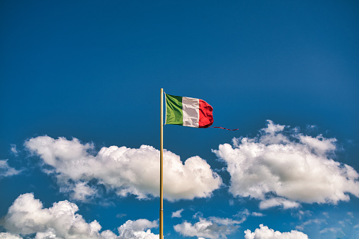 Itallian flag over blue sky in Rome
