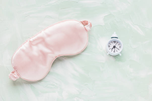istock Sleeping mask and alarm clock. Sleep disorder and evening routine concept 1389521405