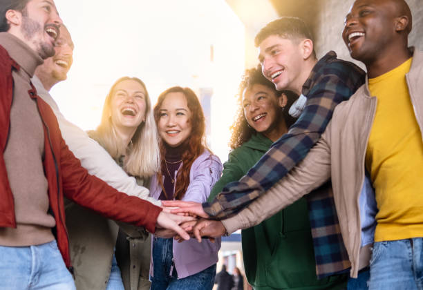 istock Multiracial happy friends with hands in stack. Multi-ethnic diverse group joining their hands - union concept - selective focus. 1389523499