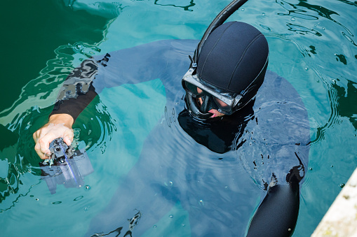 Diver in the water in a diving suit and helmet ready to dive