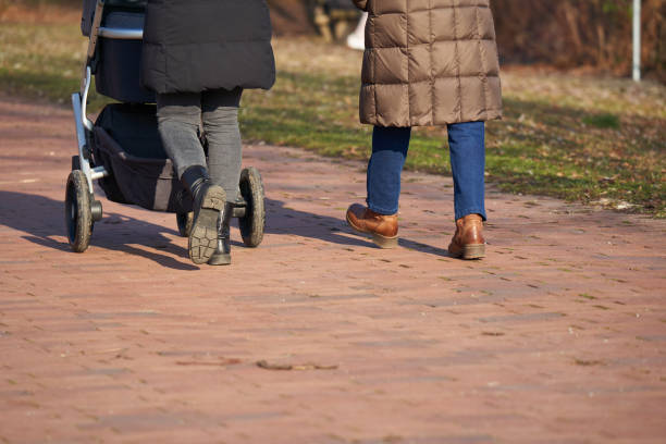 istock 2 women with strollers. People with warm clothes. Rear view. 1389524962